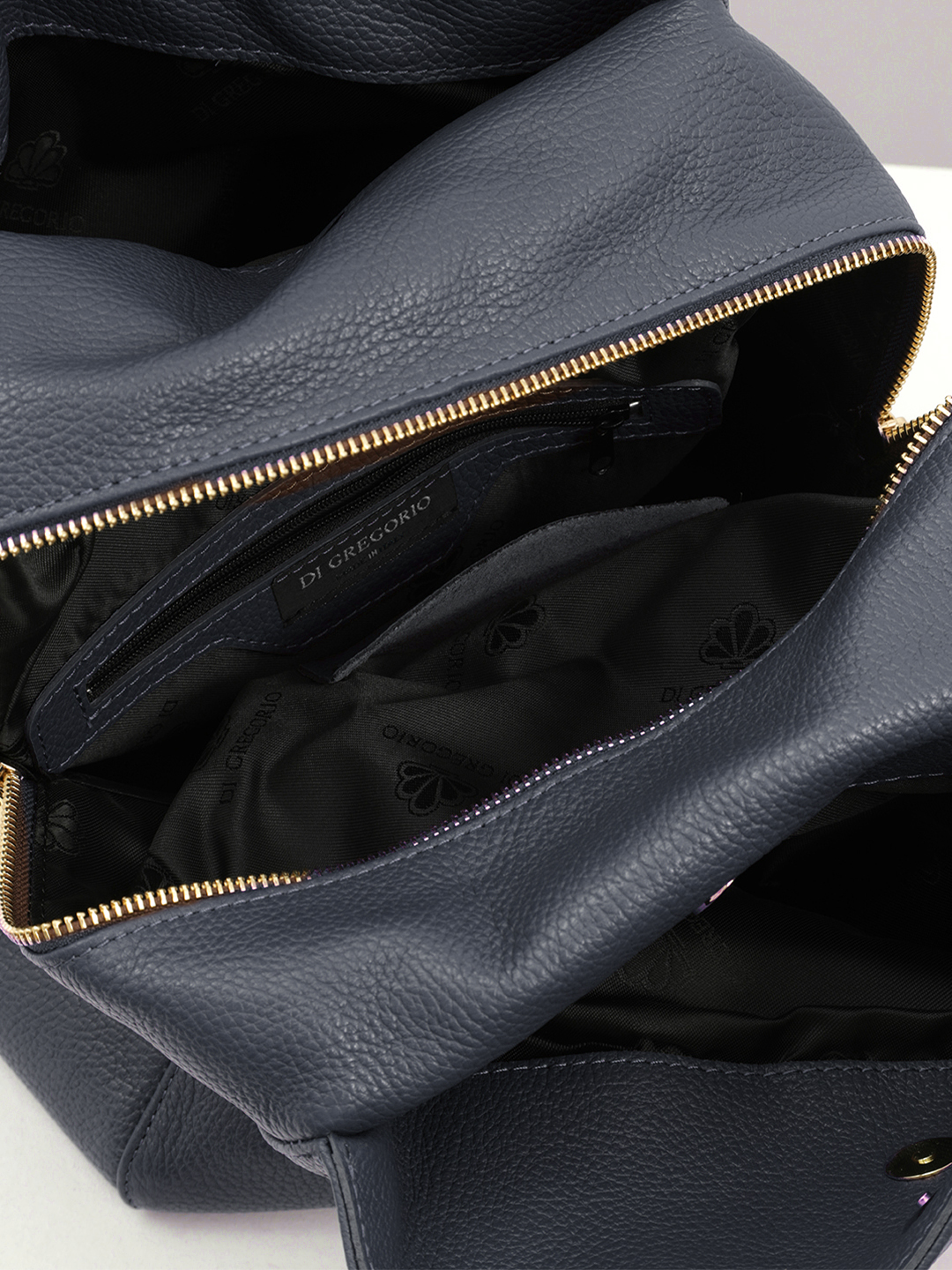 Сумка-рюкзак от Di Gregorio с акцентной круглой фурнитурой в синем цвете