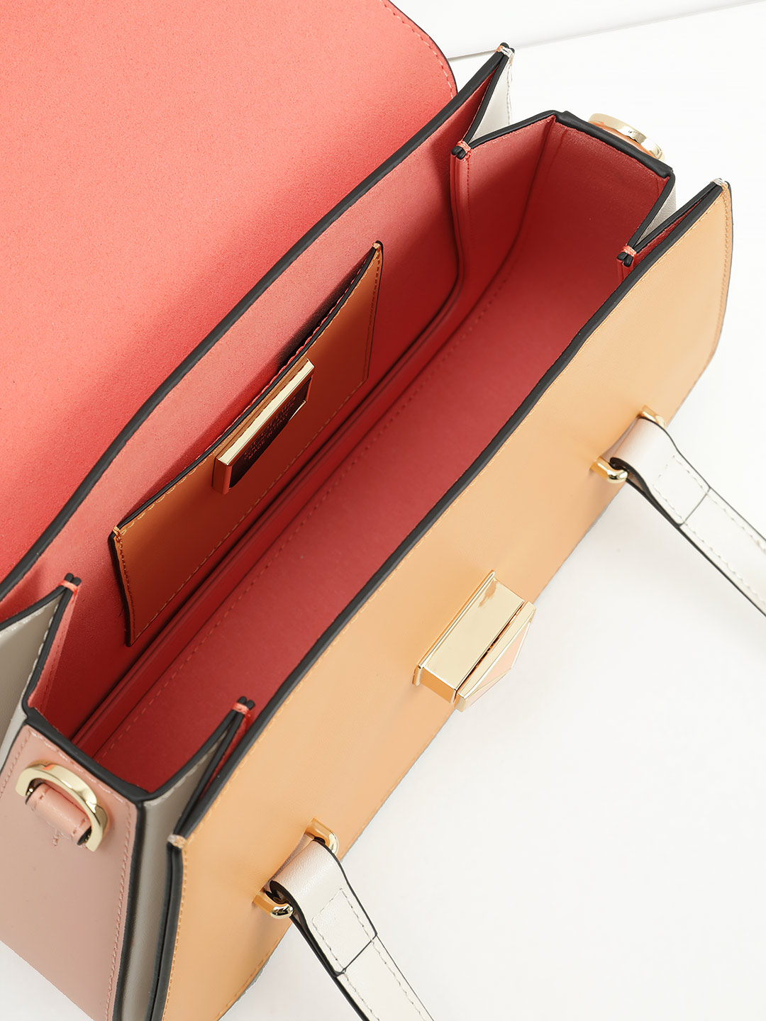 Сумка трапециевидной формы с поворотным замком на фирменной пряжке от Cromia из рыжей и розовой кожи