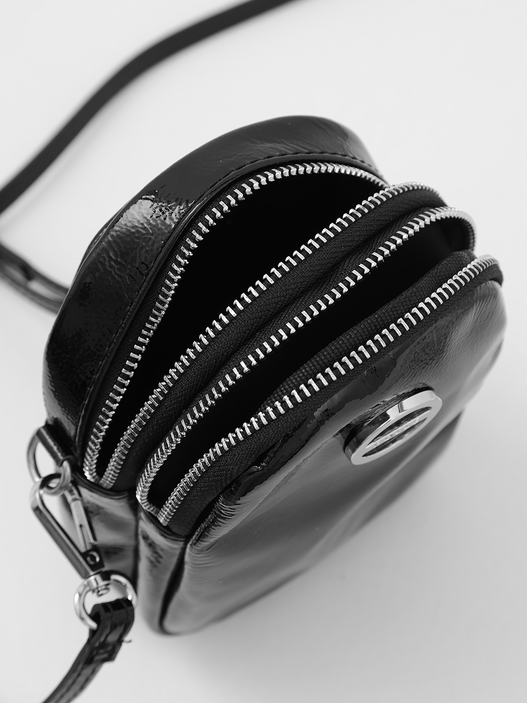 Сумка для телефона из натуральной лаковой кожи чёрного цвета с круглой фирменной фурнитурой от FOLLE